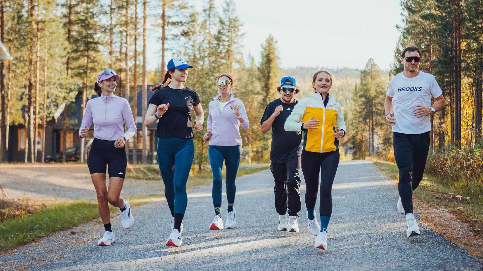 Gruppe von Läufern joggt gemeinsam auf einem malerischen Waldweg im Freien.