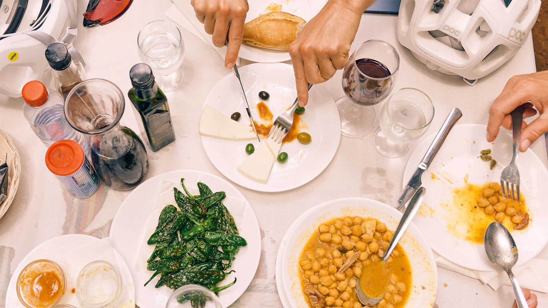 Leckeres Essen auf einem Tisch: Salat, Kichererbsen, Oliven und Wein.